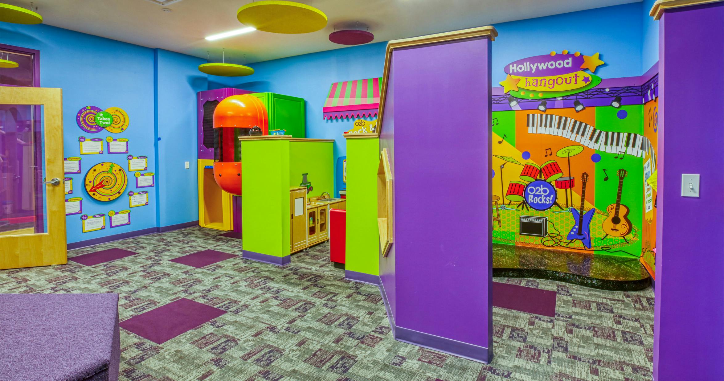Colorful playroom with a play kitchen and a Hollywood Hangout mural with instruments