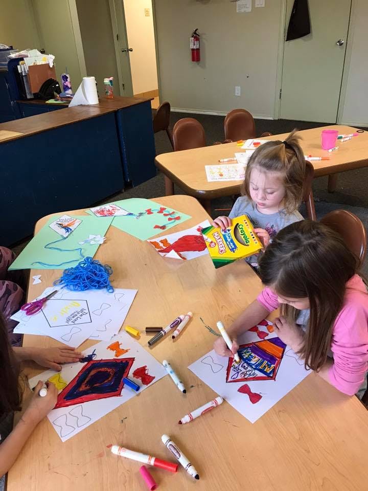 Children coloring at a table in a classroom