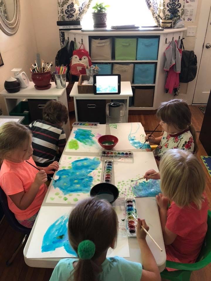 Children painting with watercolors at a table