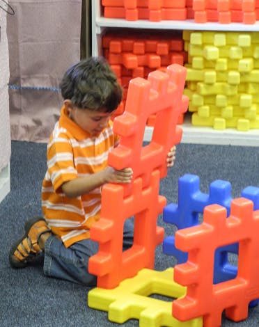 Child playing with large interlocking building blocks