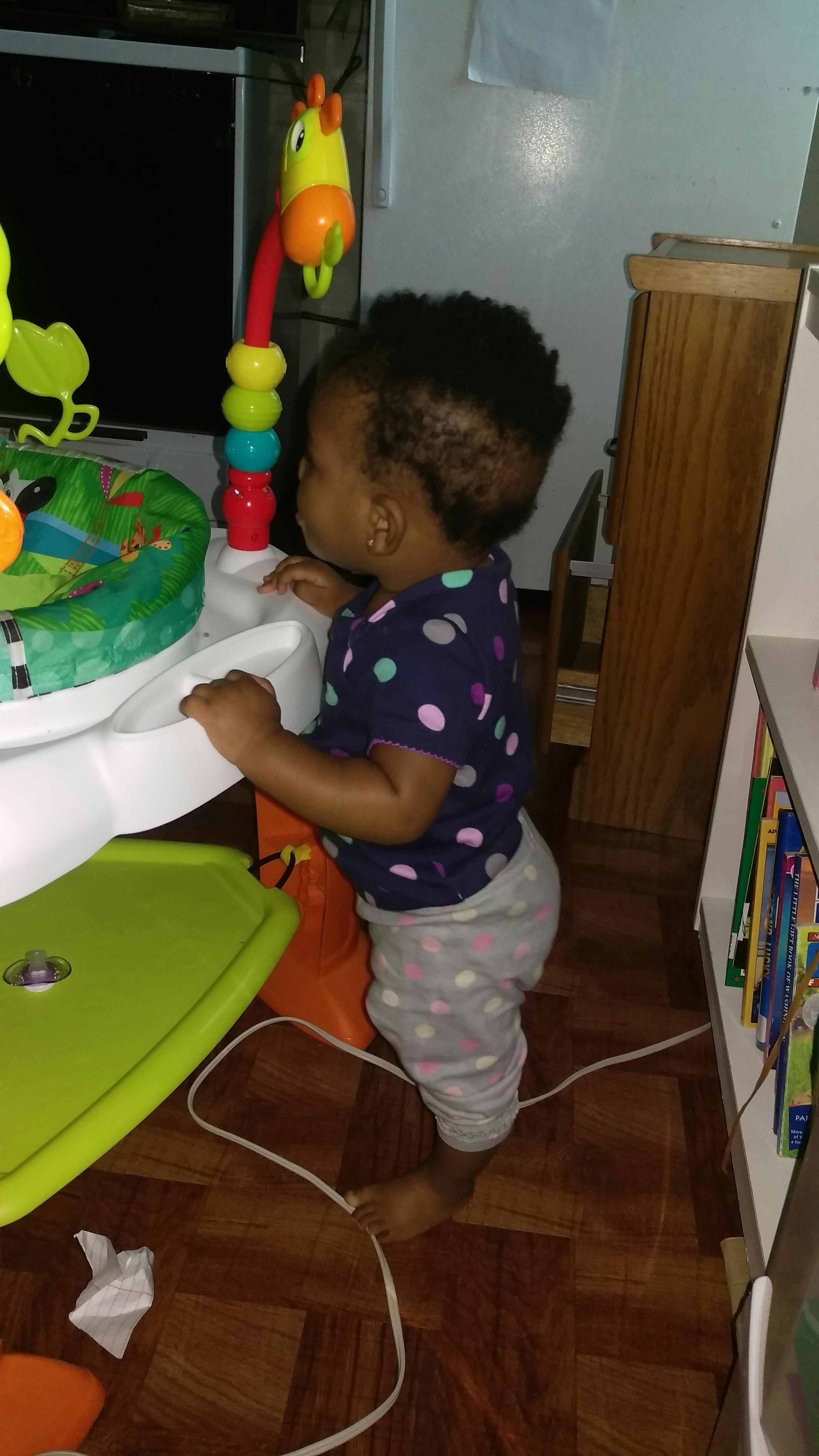 Child standing in a baby bouncer
