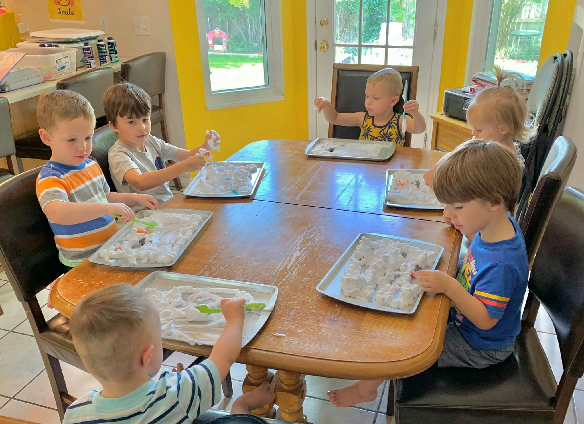 Children at a table with trays of craft materials