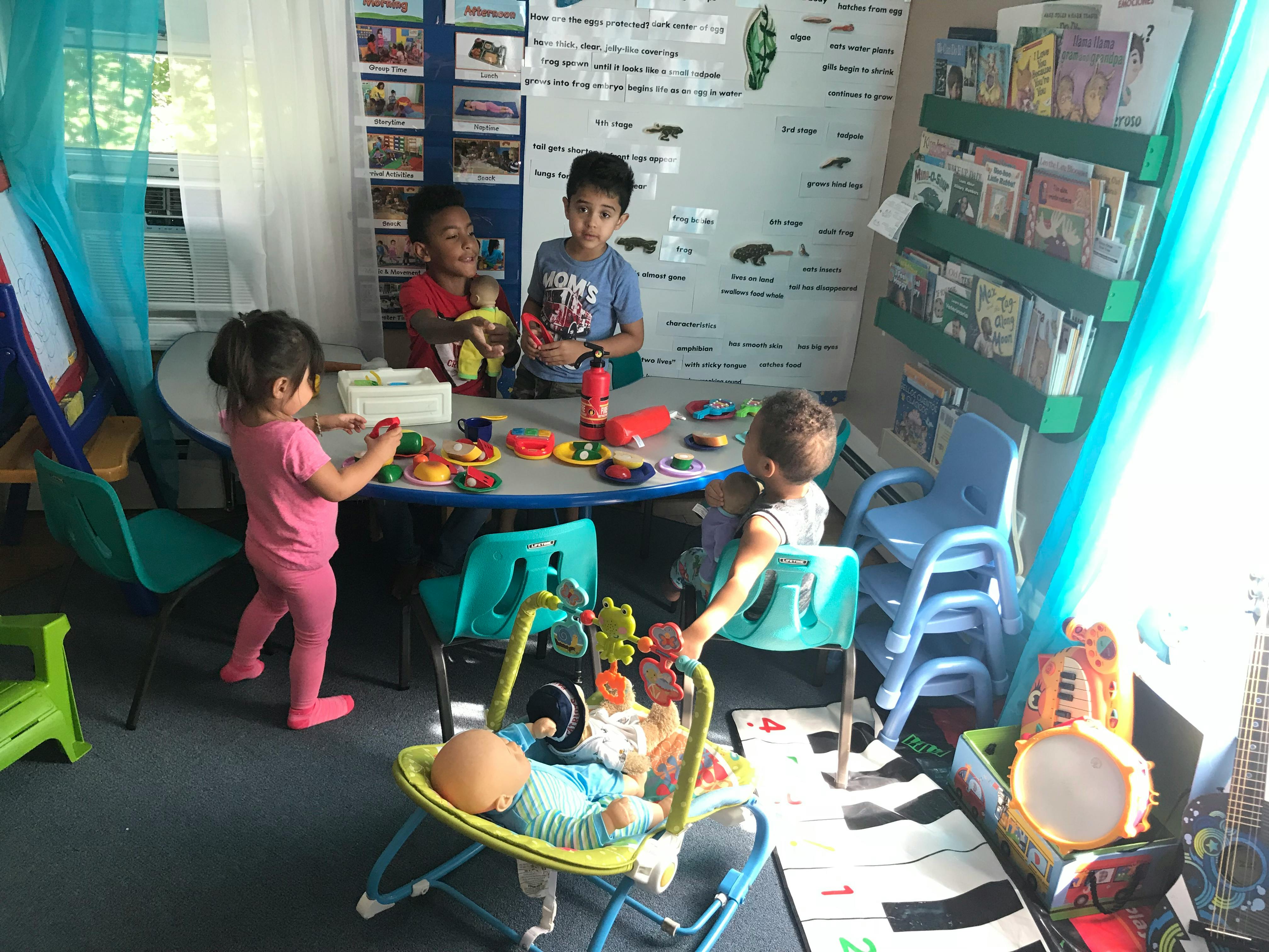 Children playing with toys around a table in a room