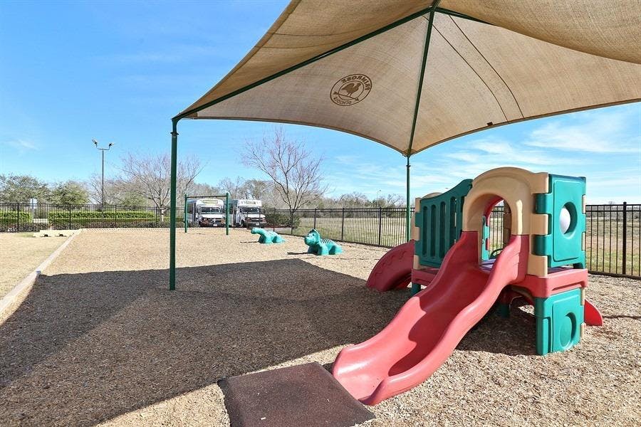 Playground with a red slide and a shade canopy