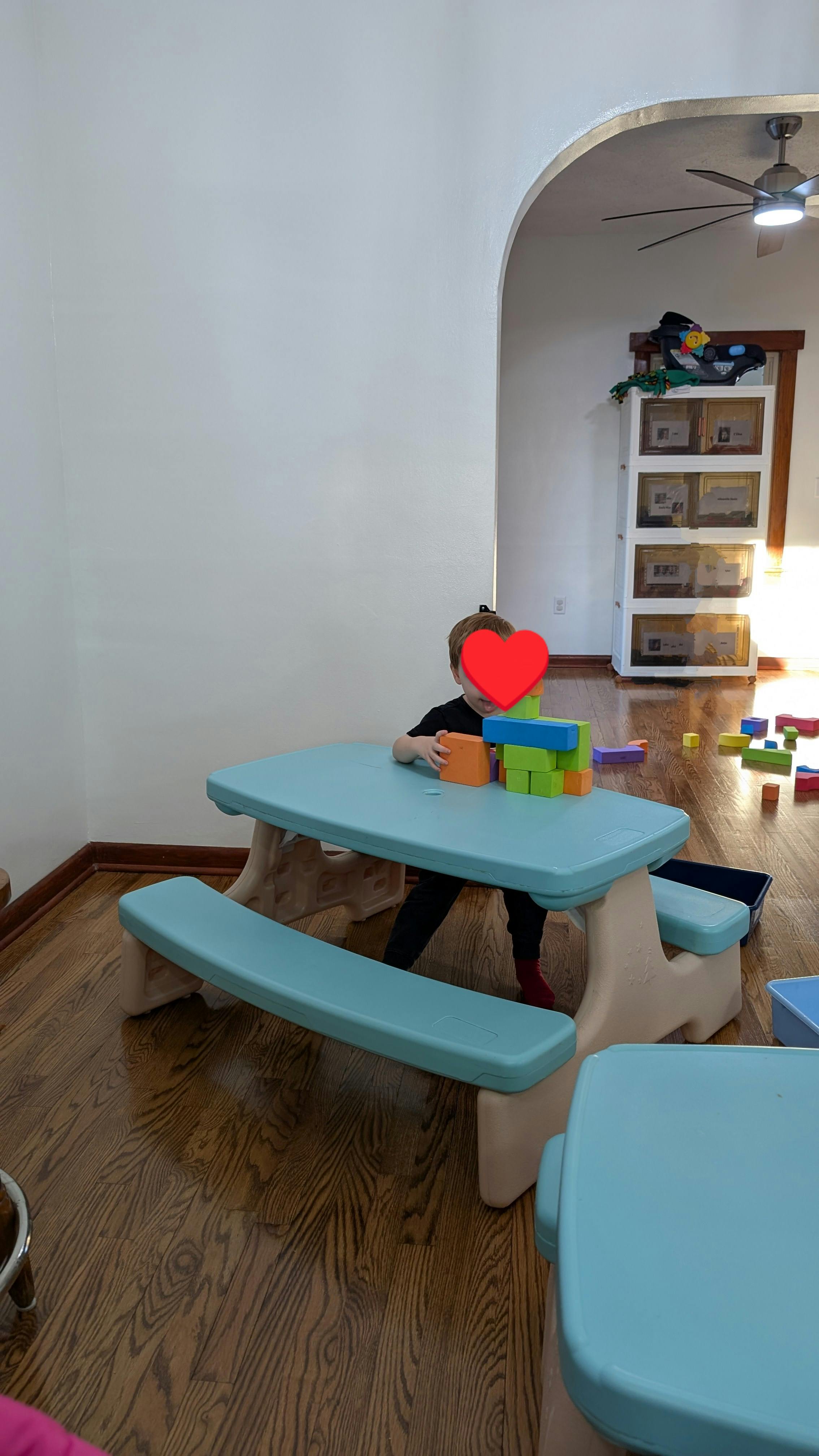 Child playing with colorful blocks at a small table