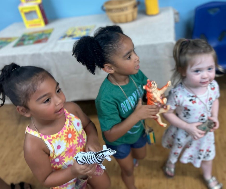 Three children playing with animal toys