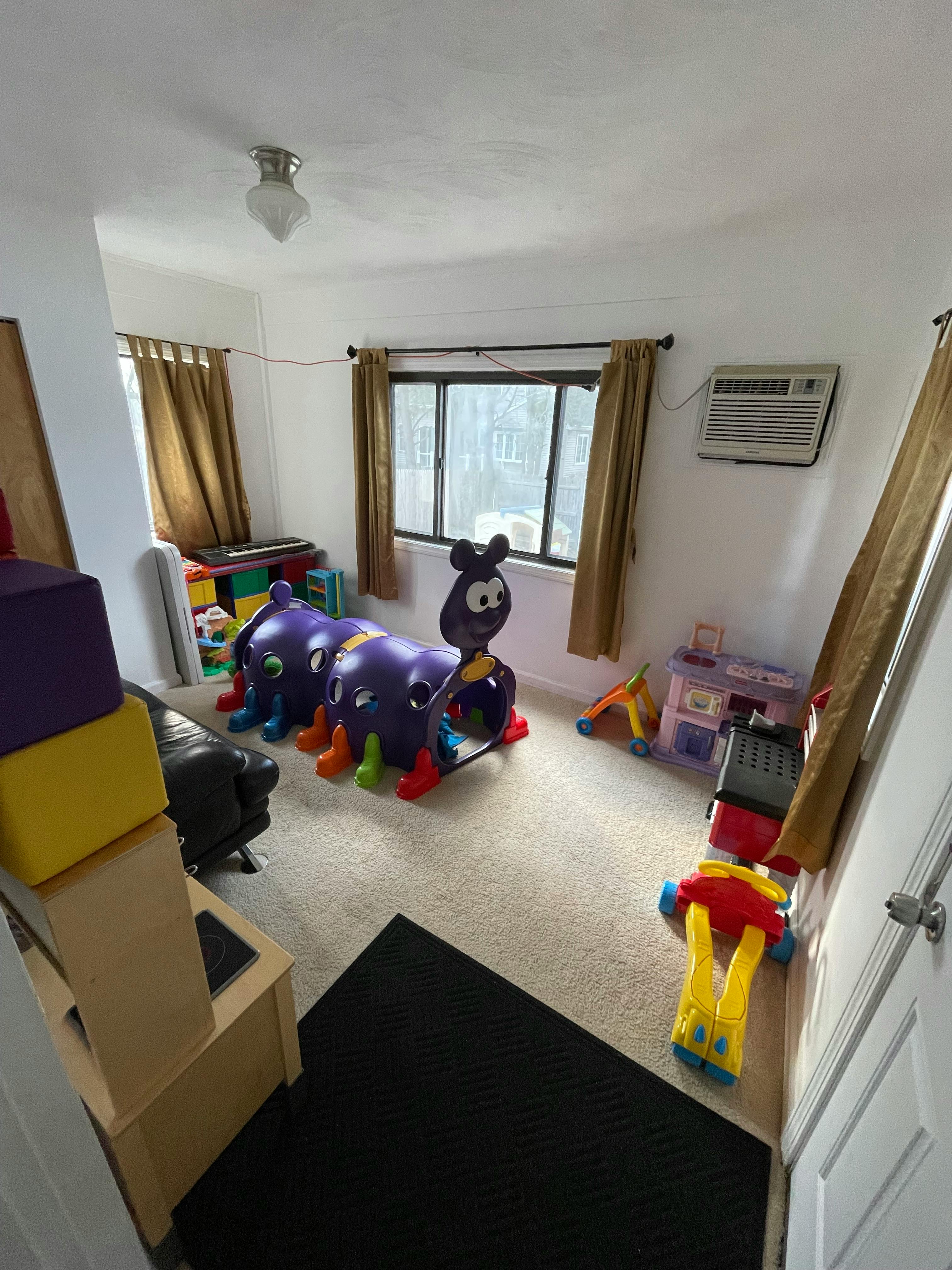 Playroom with a purple caterpillar tunnel and other toys