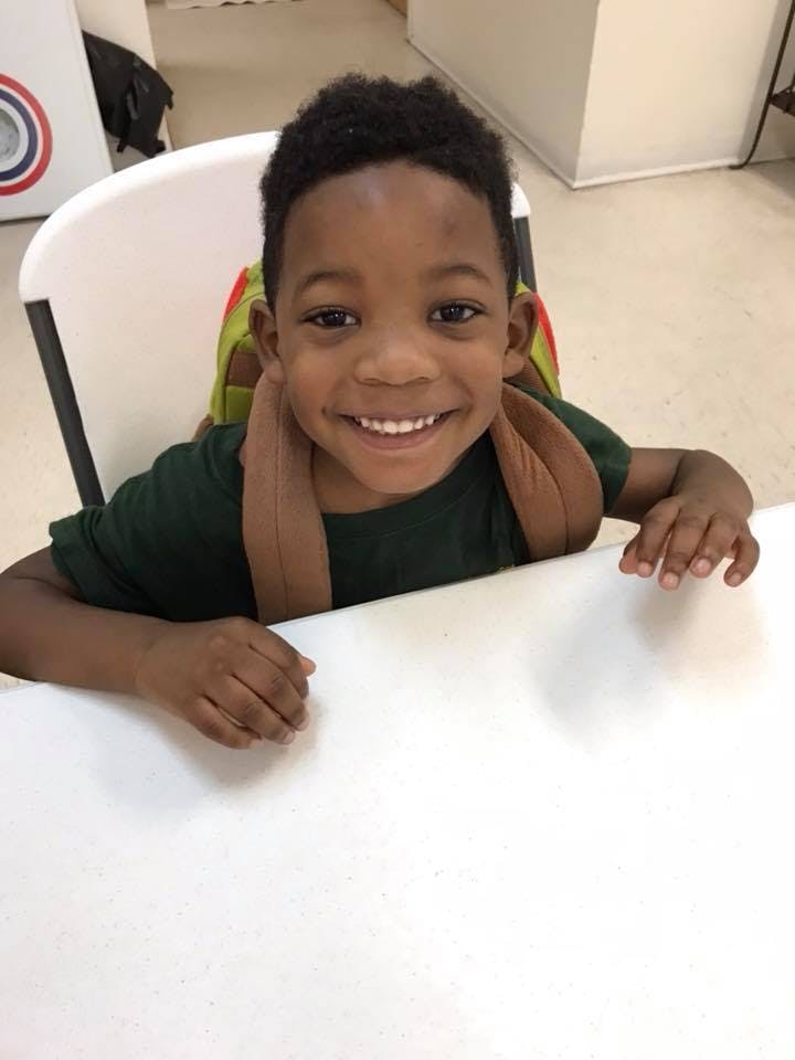 Child smiling at a table