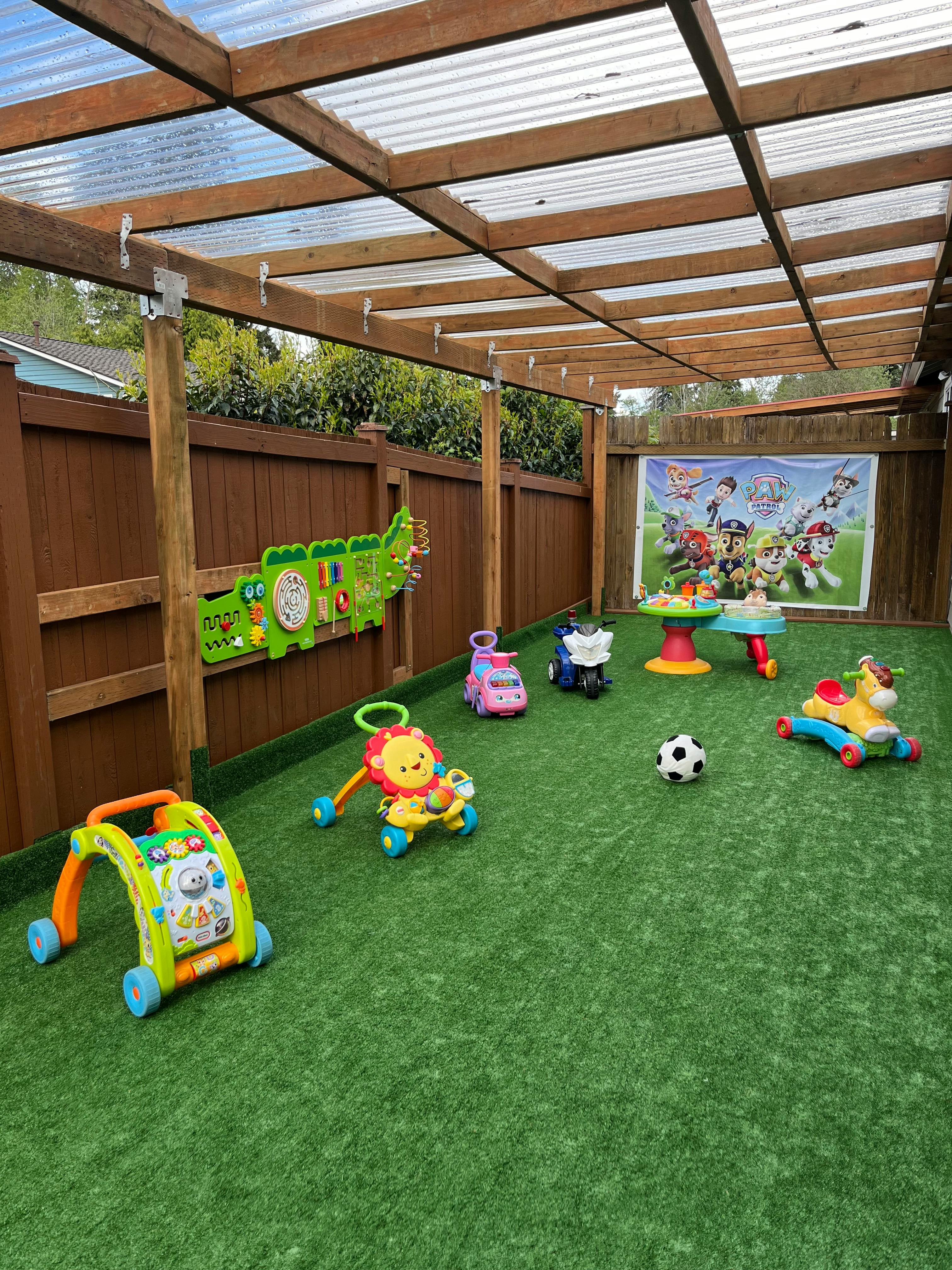 Outdoor play area with various toys on artificial grass
