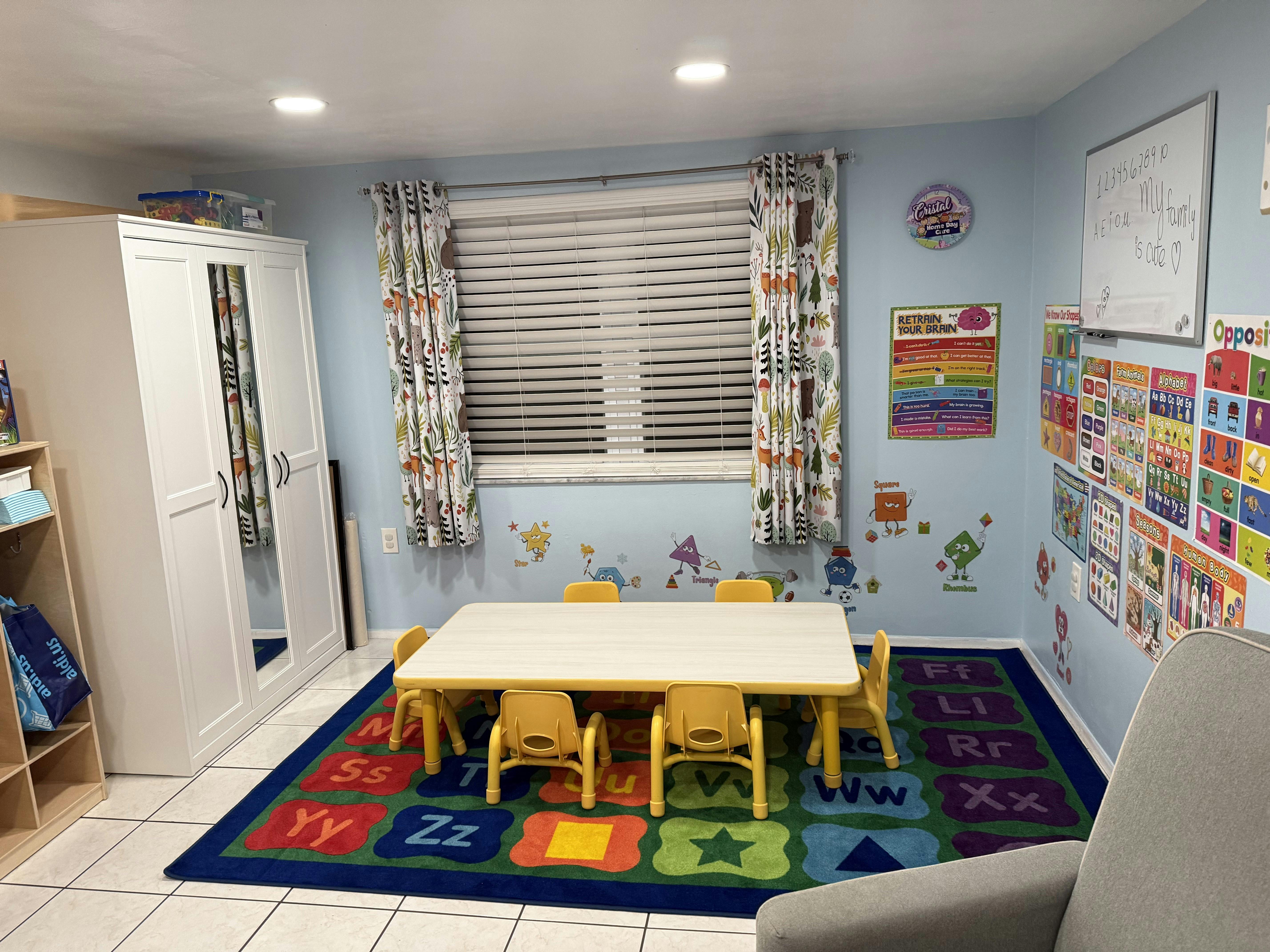 Children's classroom with small table and chairs on an alphabet rug