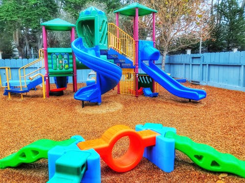 Colorful playground with slides and climbing structures on wood chips