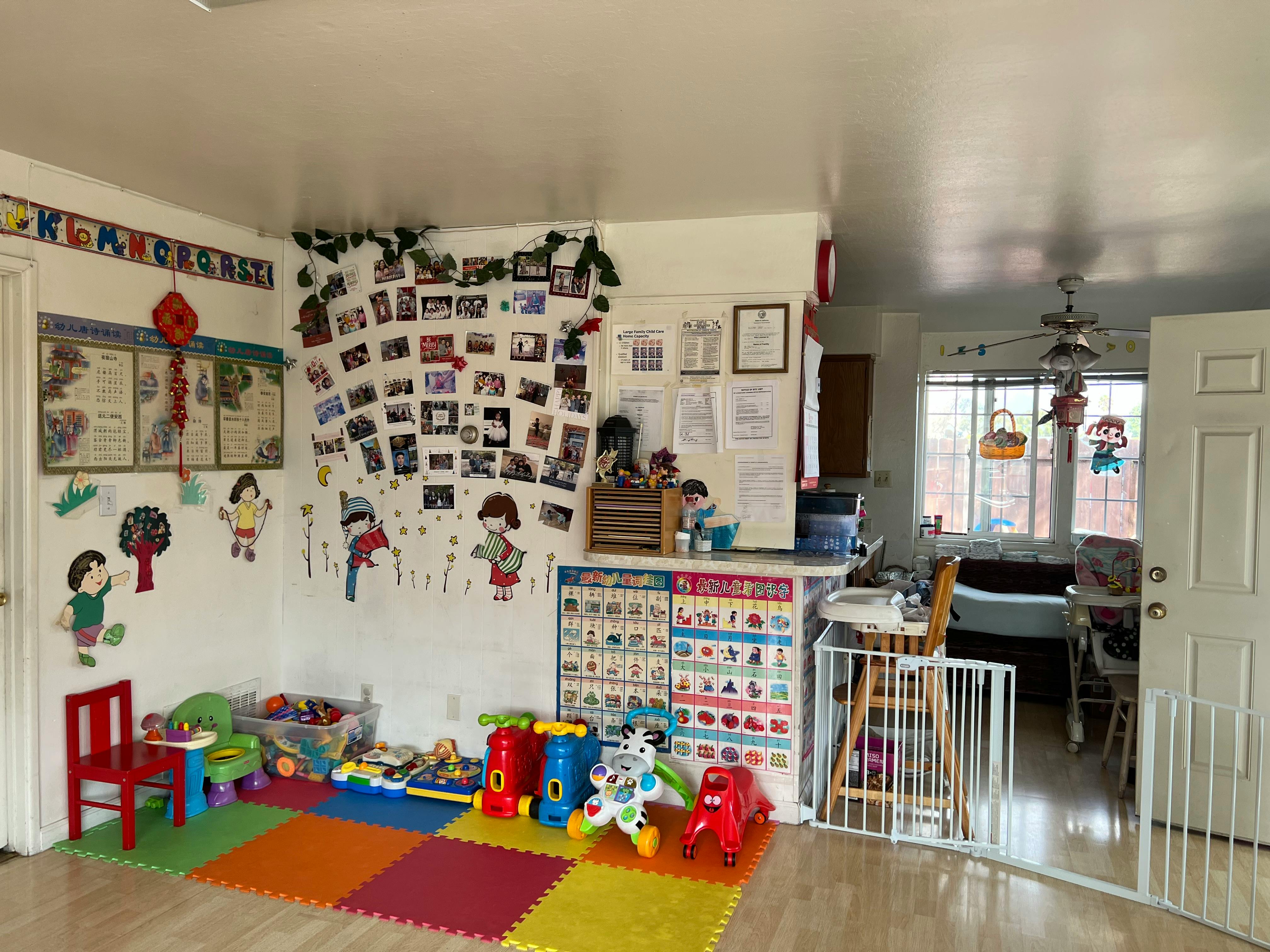 Playroom with colorful floor mats, toys, and child-themed wall decorations