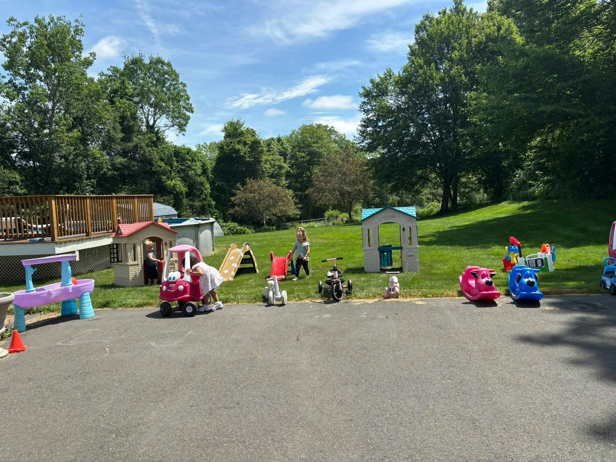 Children playing with toys and playhouses outdoors