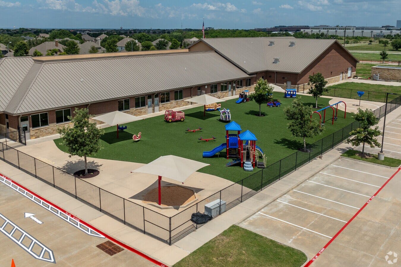 Aerial view of a school playground with equipment and shade structures