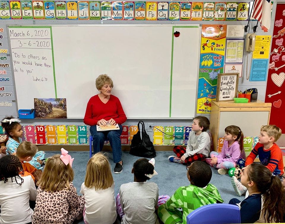 Person reading to children in a classroom