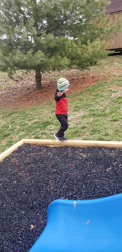 Child walking on a wooden beam on a playground