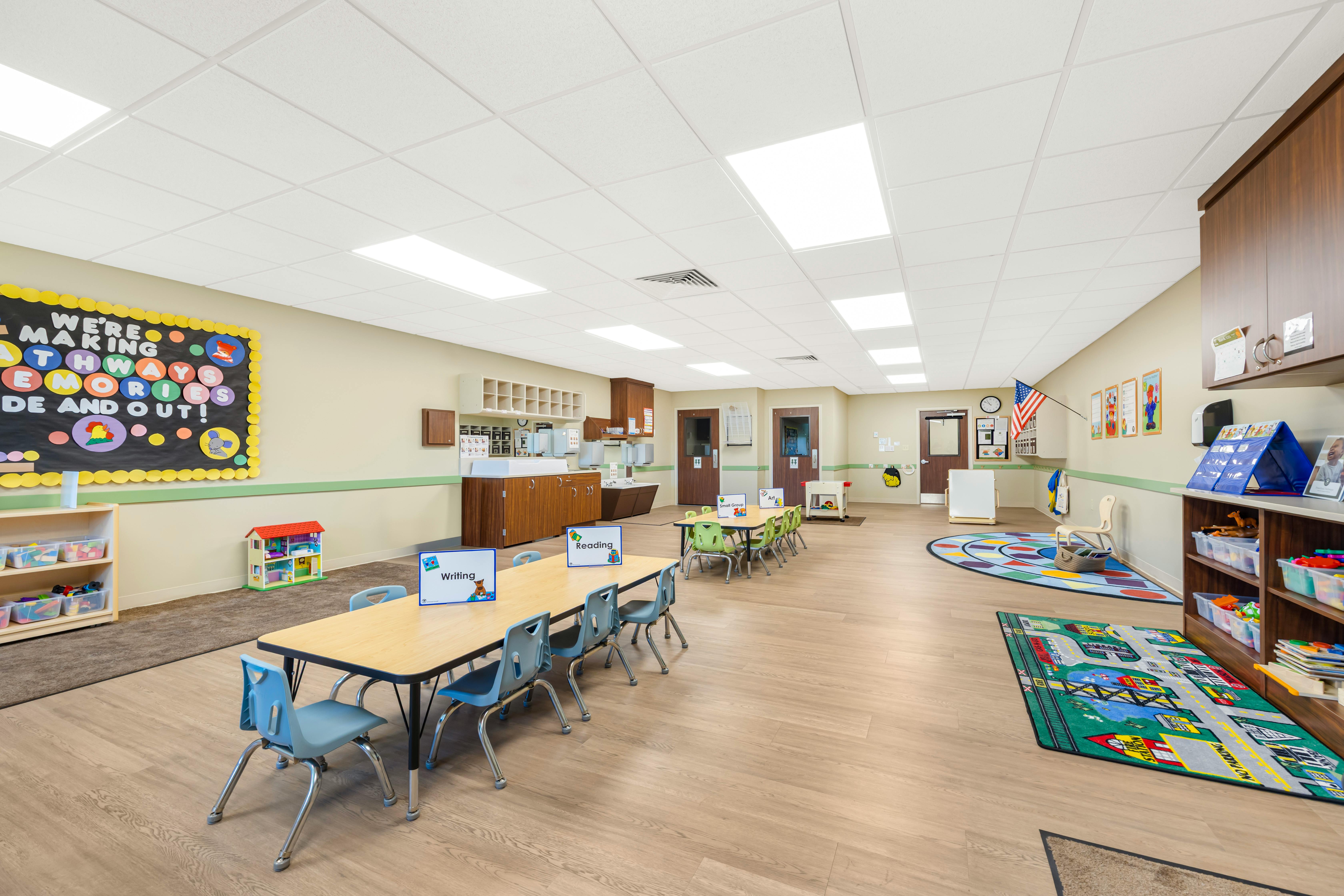 Empty colorful children's classroom with tables and chairs