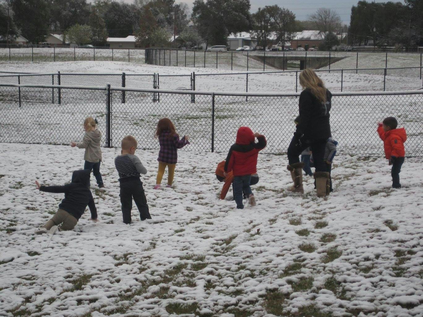 Adult and children playing in snow