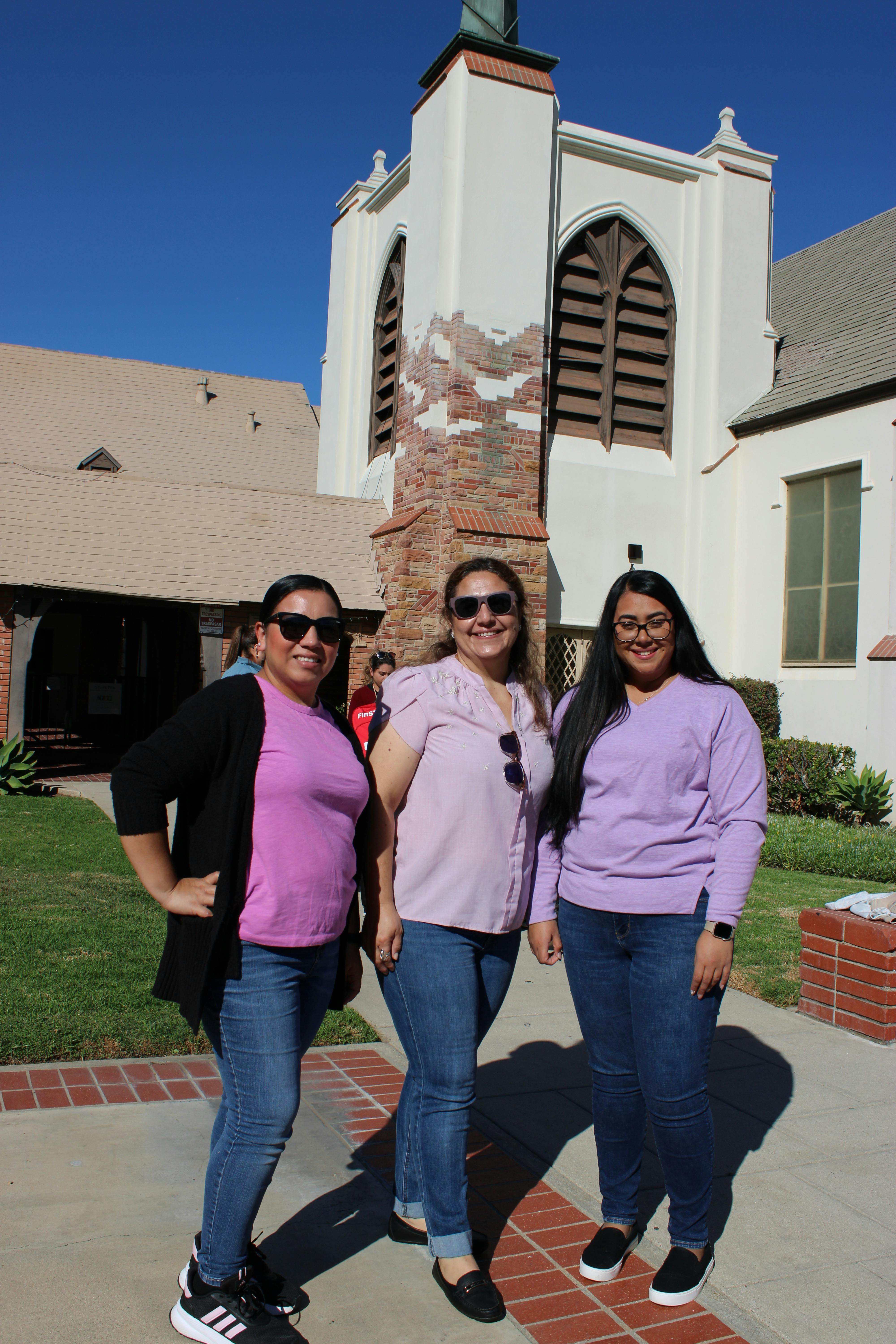 Three people smiling and posing for a photo outdoors