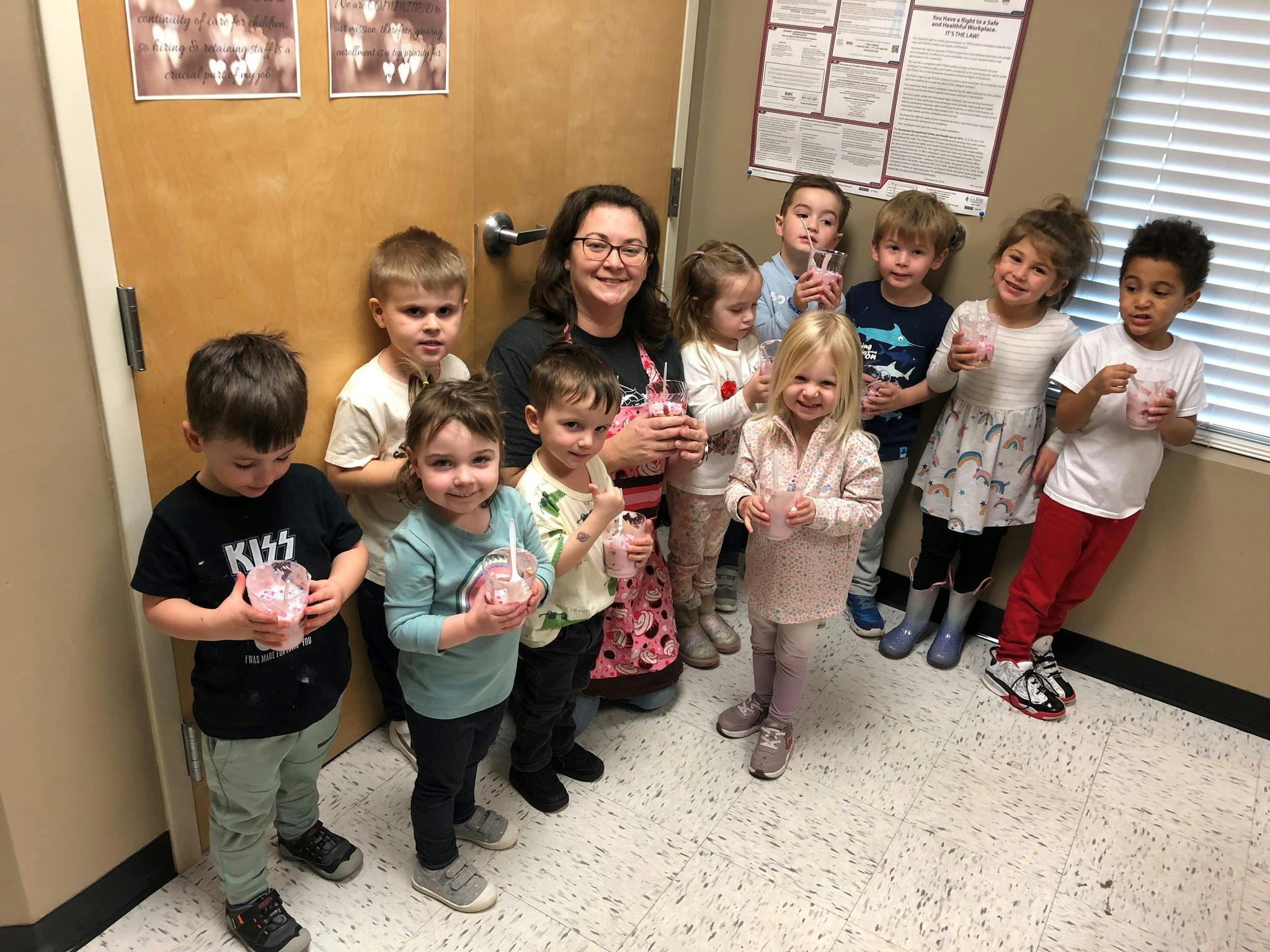 Adult and children holding cups with straws