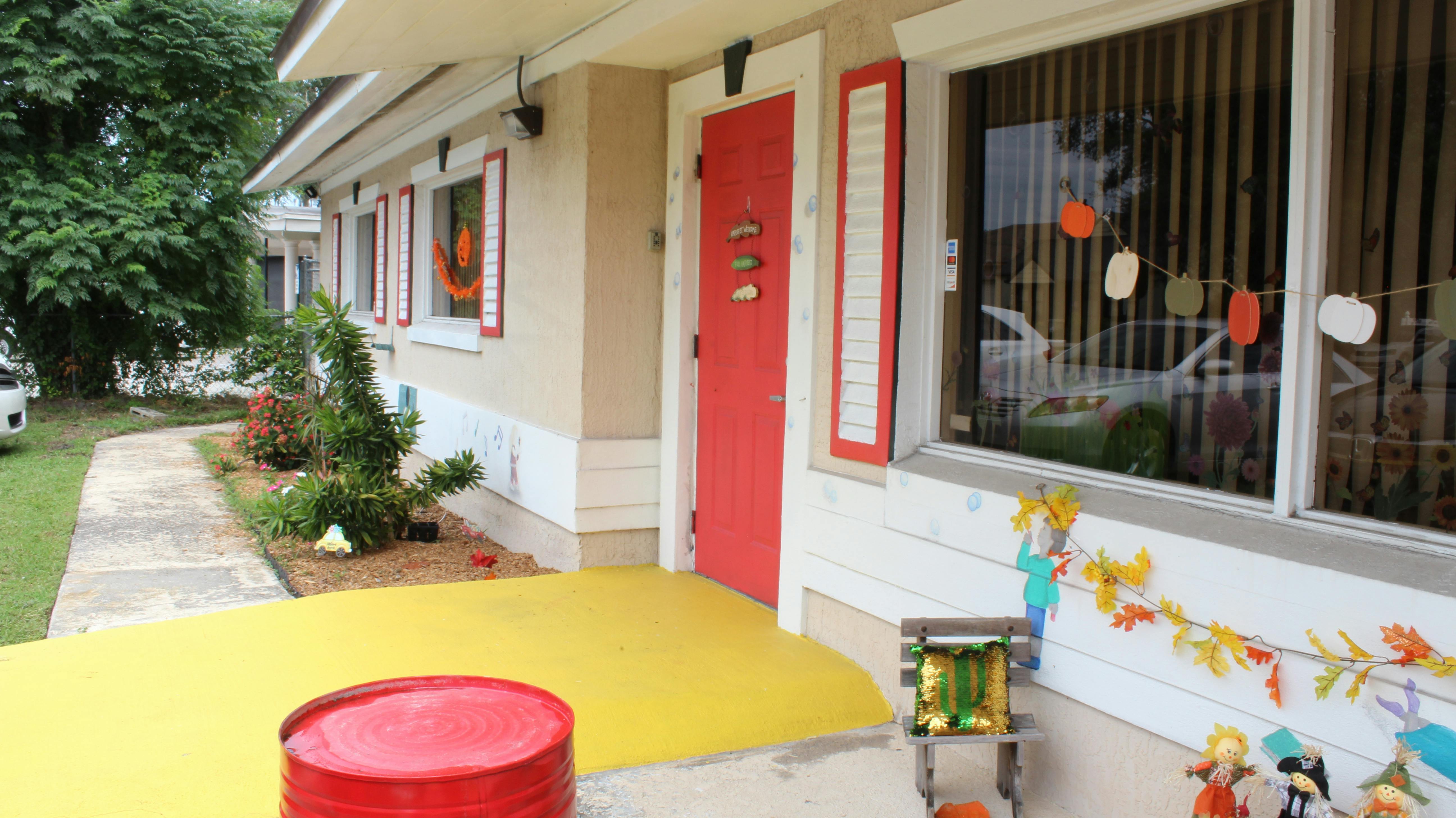 Exterior of a building with a red door and yellow porch