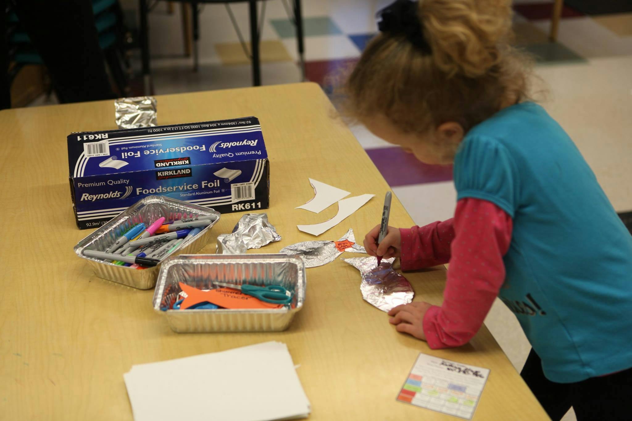 Child drawing on a piece of paper at a table