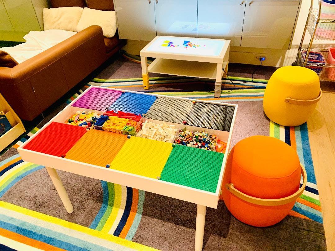 Play table with colorful building blocks and two round stools
