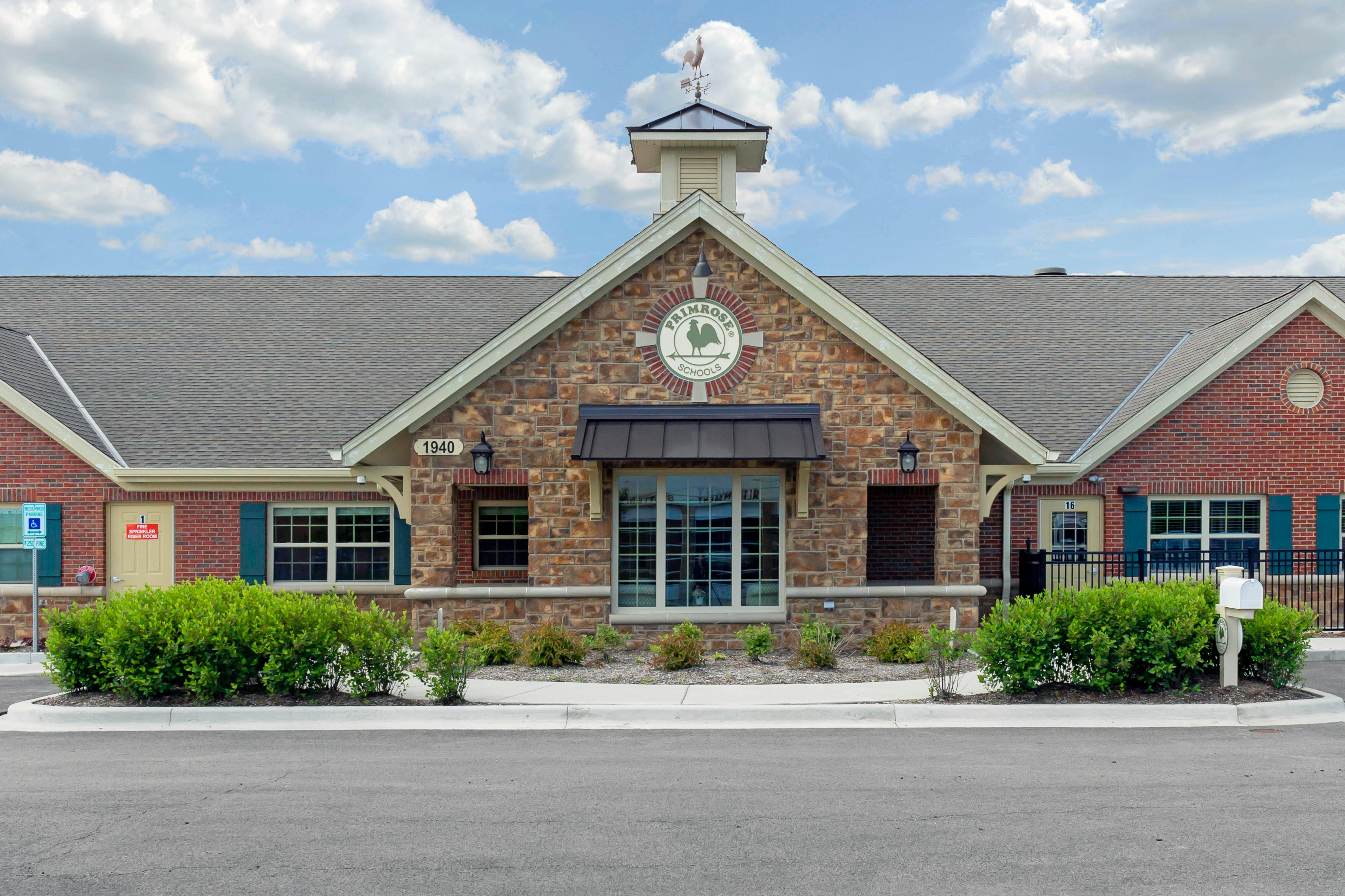 Primrose School building exterior with a weathervane and logo on the facade