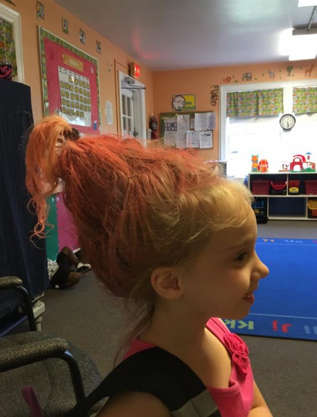 Child with hair styled high in a ponytail