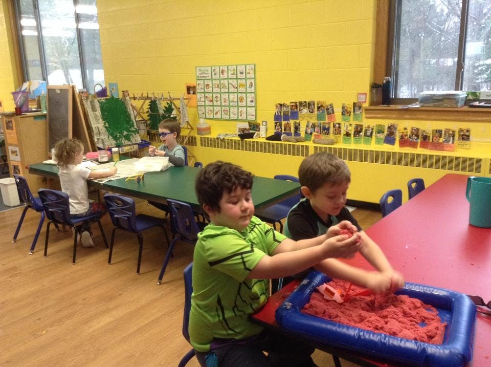Children playing with kinetic sand in a classroom
