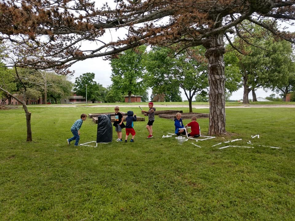 Children playing outdoors under a tree