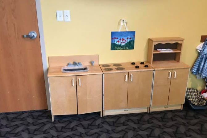 Children's play kitchen set with sink, stove, and cabinets