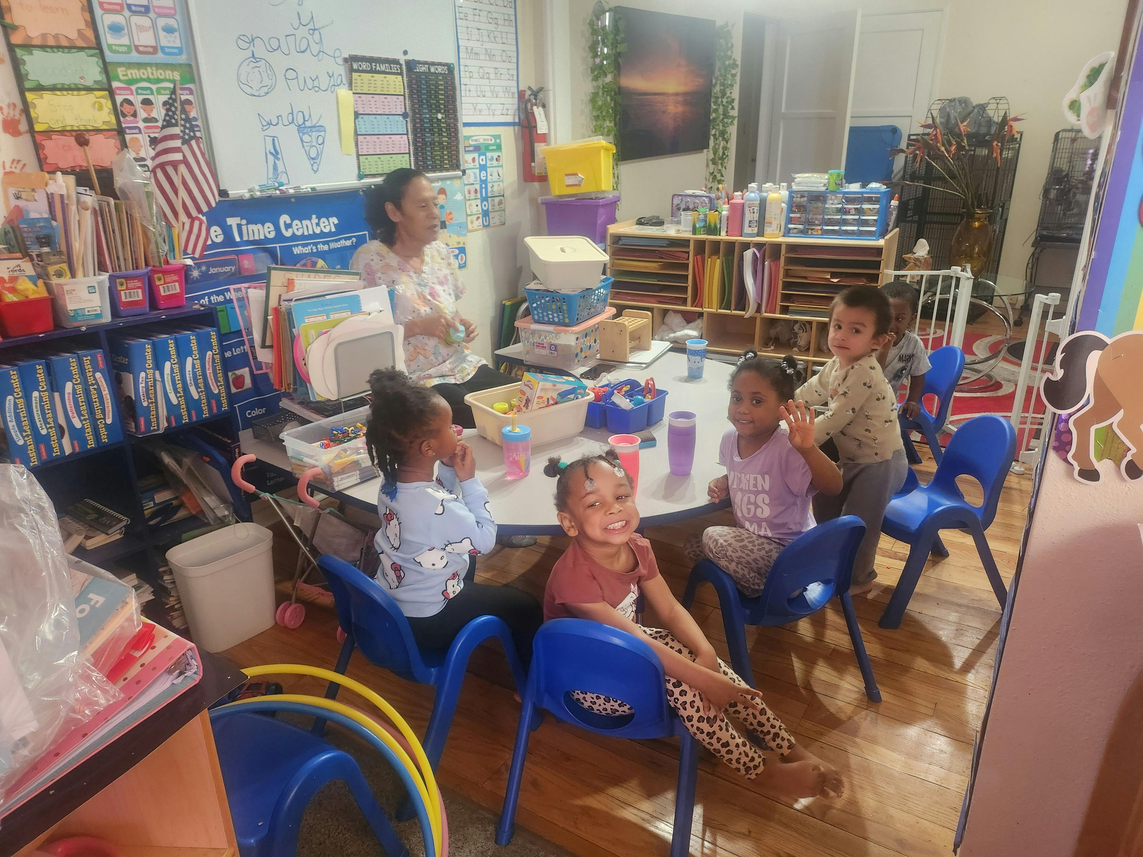 Adult and children sitting around a table in a classroom