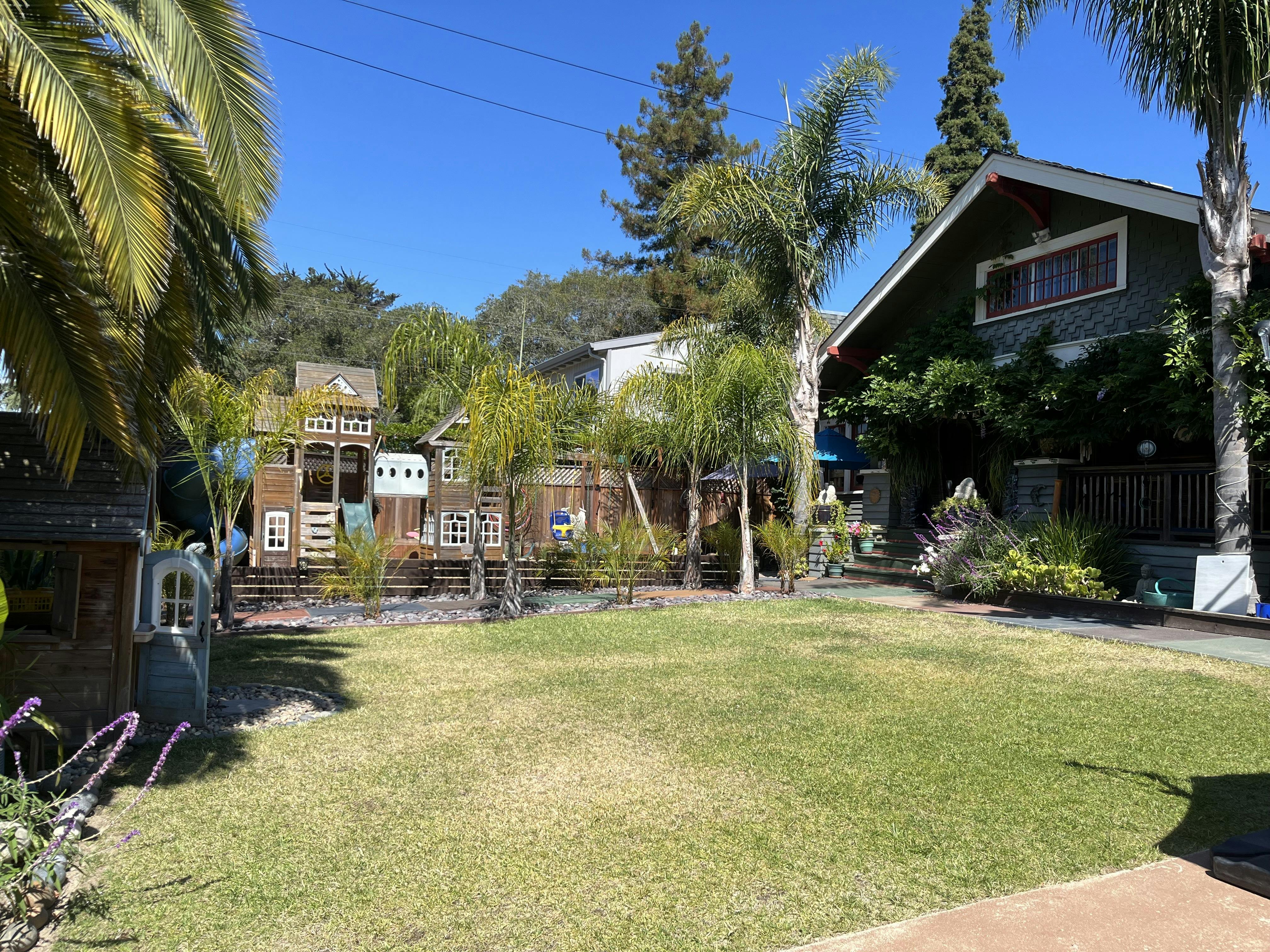 Backyard with a wooden play structure and a house
