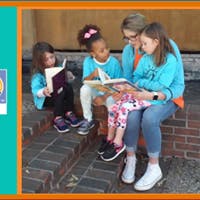 Adult and three children reading books together