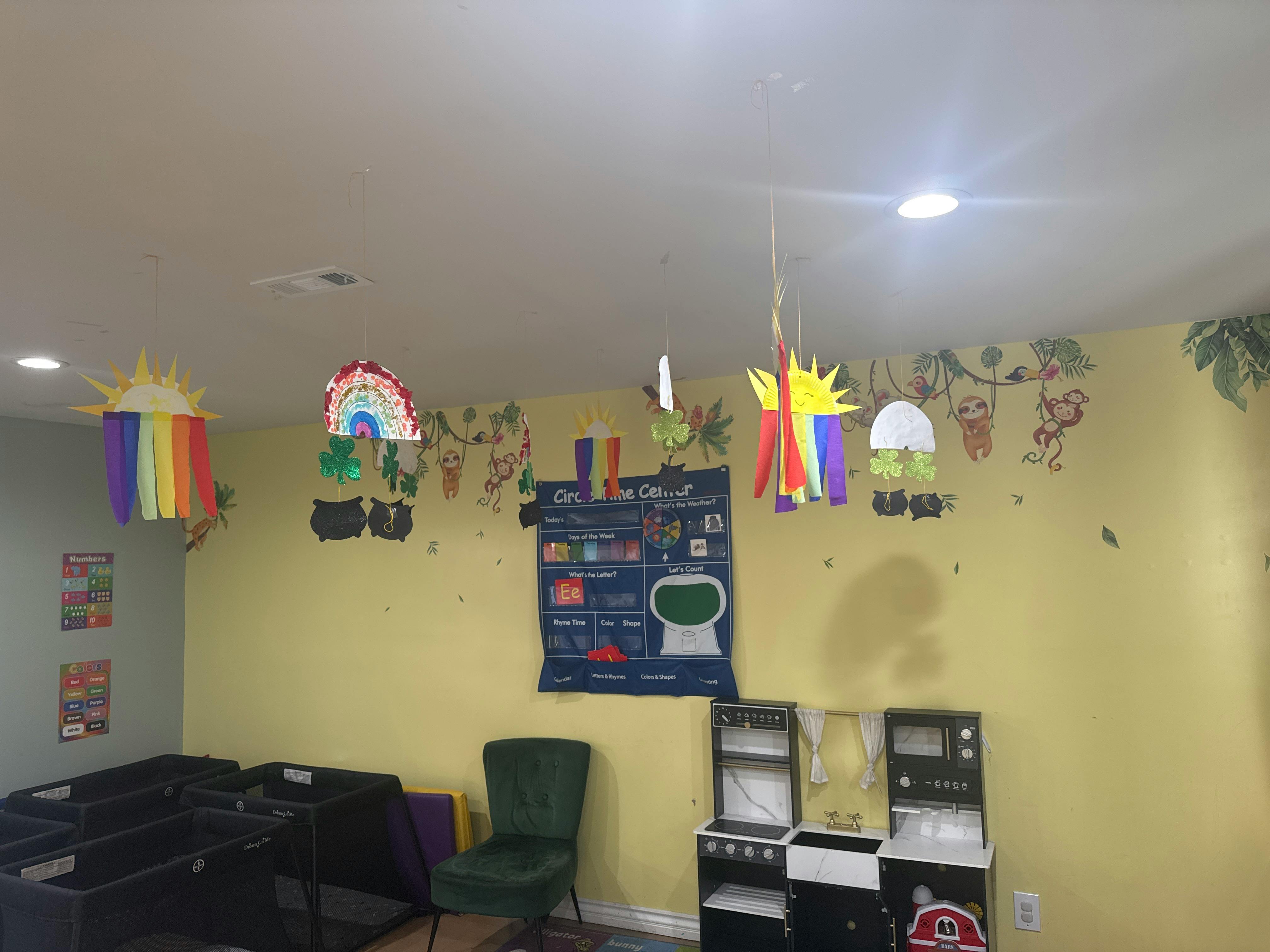 Children's classroom with cots, toy kitchen, and wall decorations