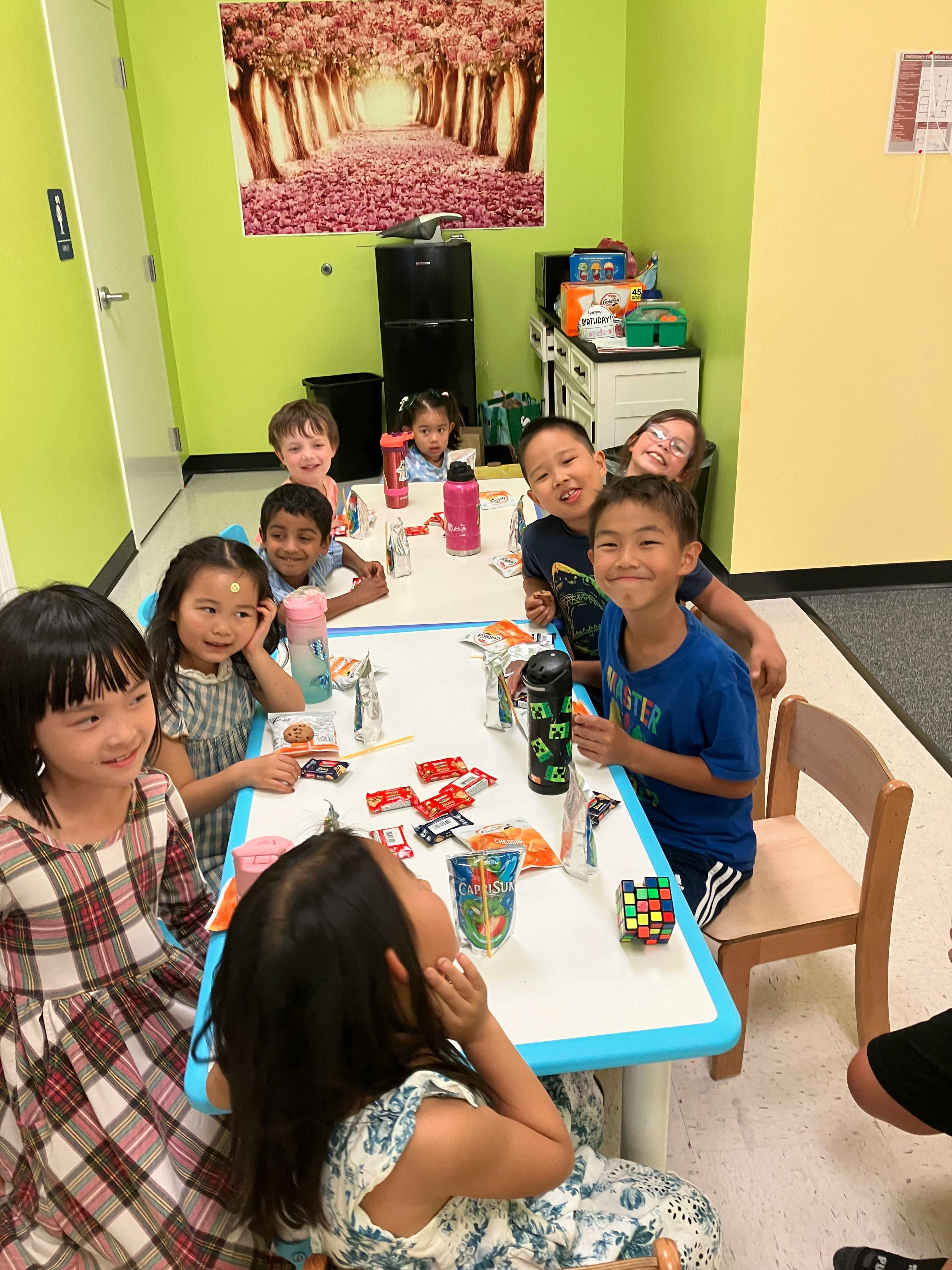 Group of children sitting at tables in a classroom