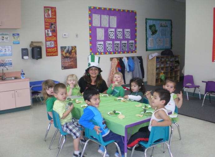 Adult and children sitting around a table in a classroom