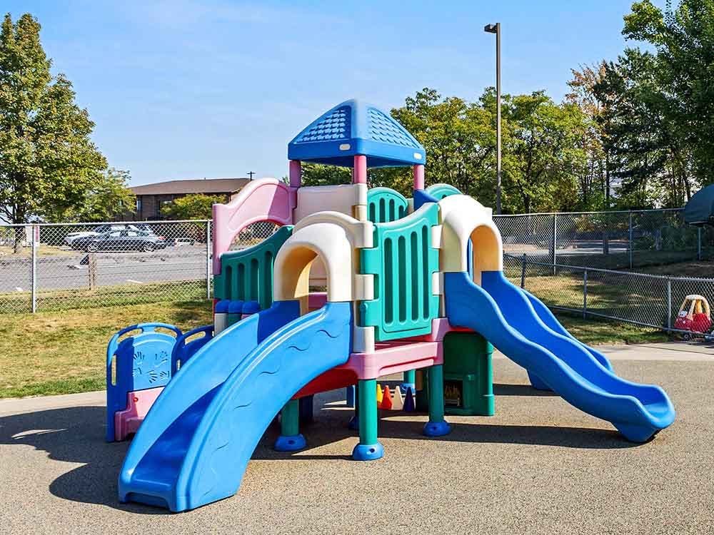 Playground equipment with two blue slides and a colorful play structure