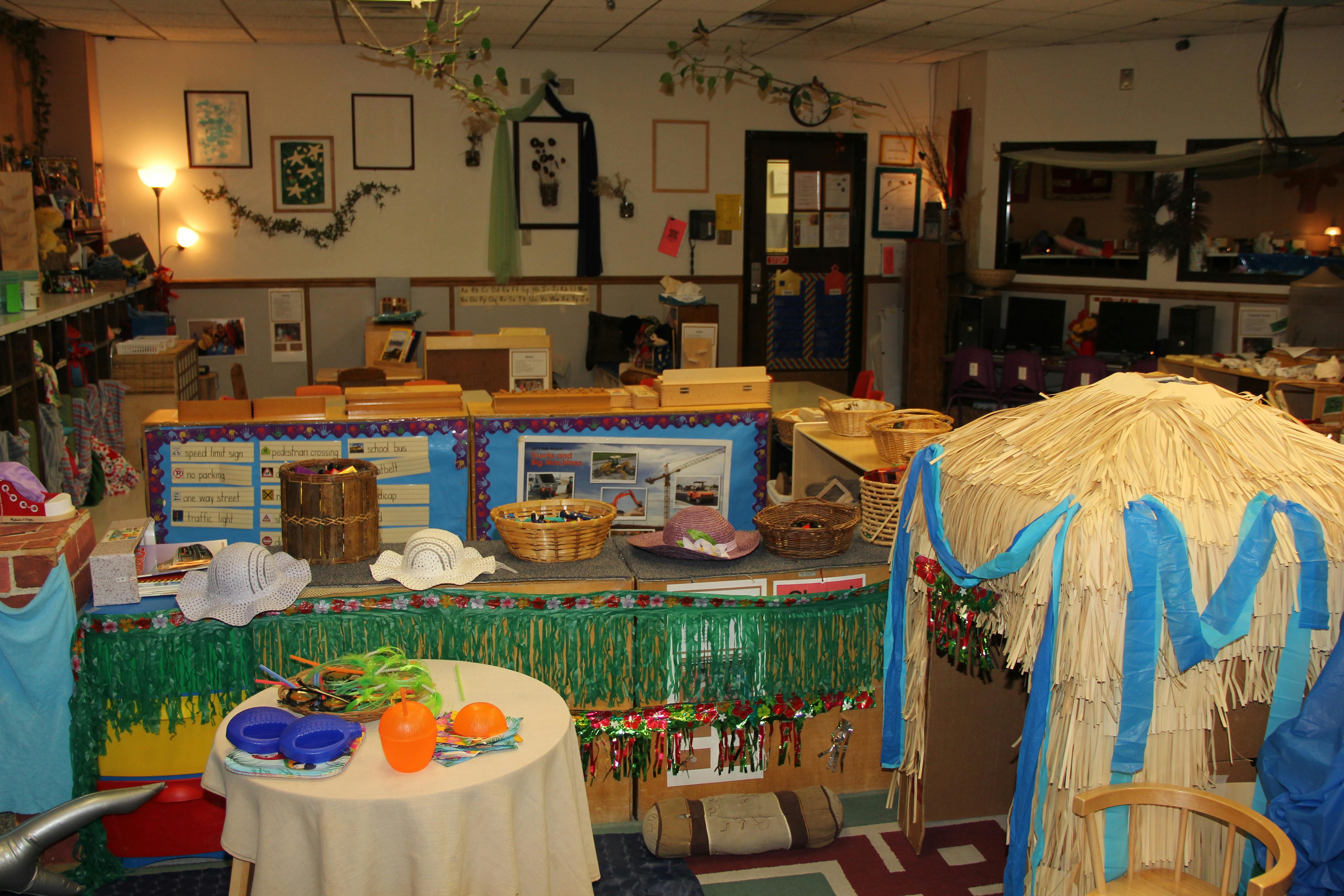Room decorated with a grass skirt table and a straw hut