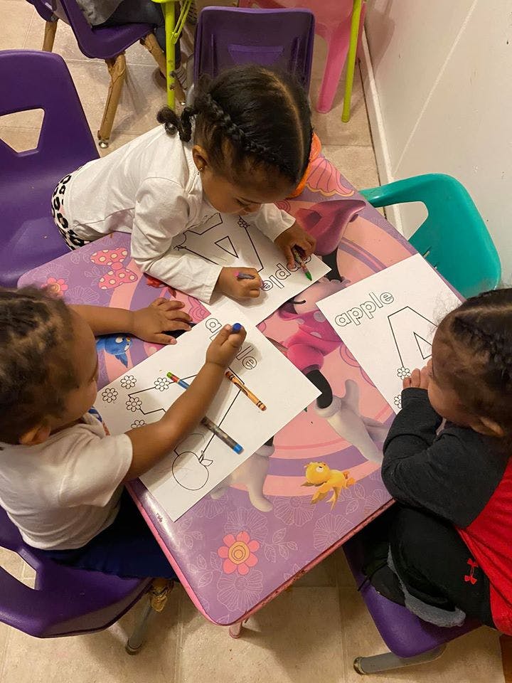 Three children coloring at a table