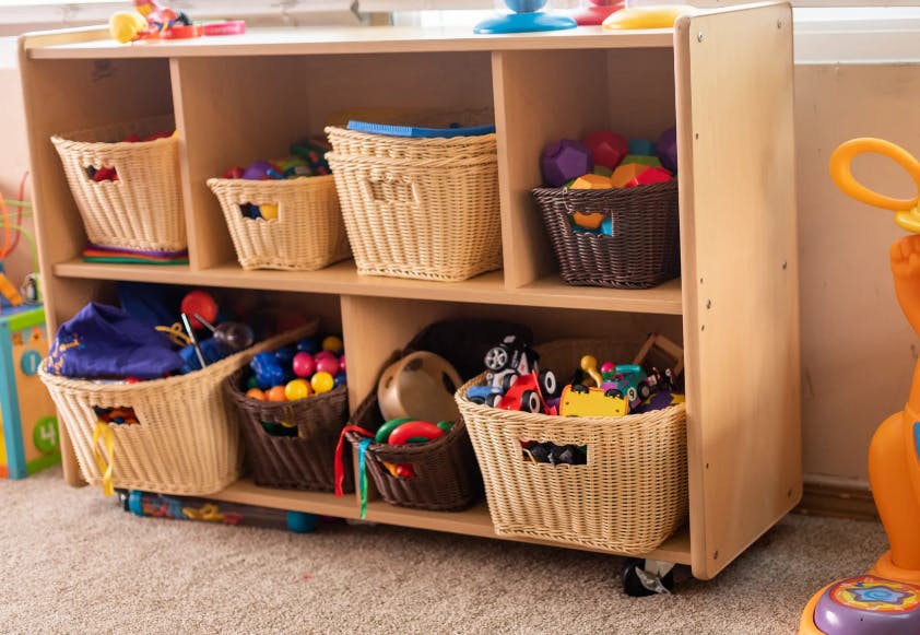 Wooden storage unit with baskets filled with toys