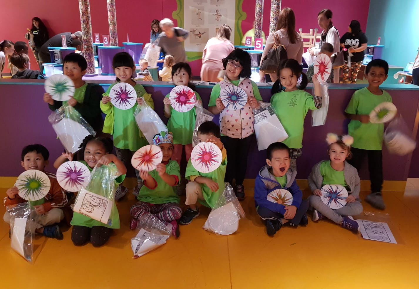 Group of children holding up paper crafts