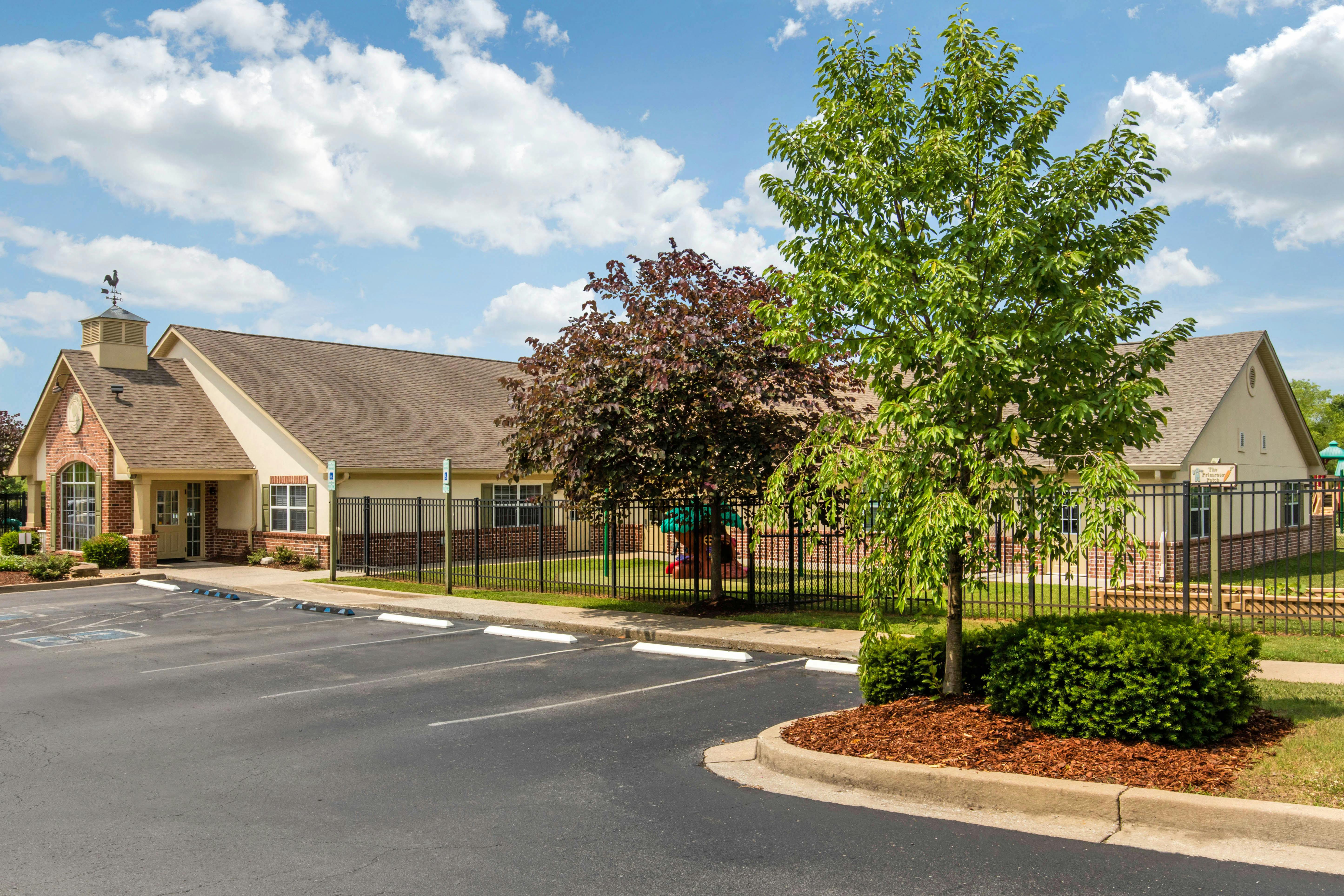 Exterior view of a school with a parking lot and a playground