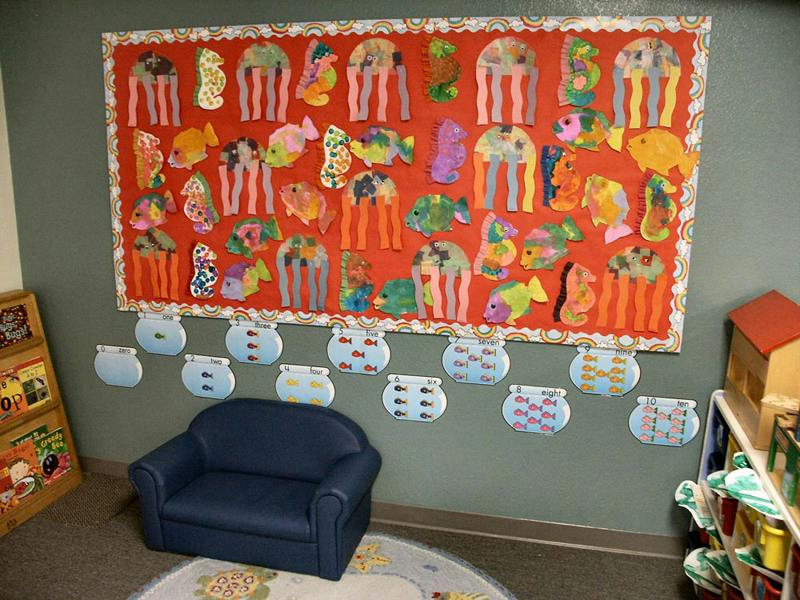 Children's artwork of fish and jellyfish on a red bulletin board