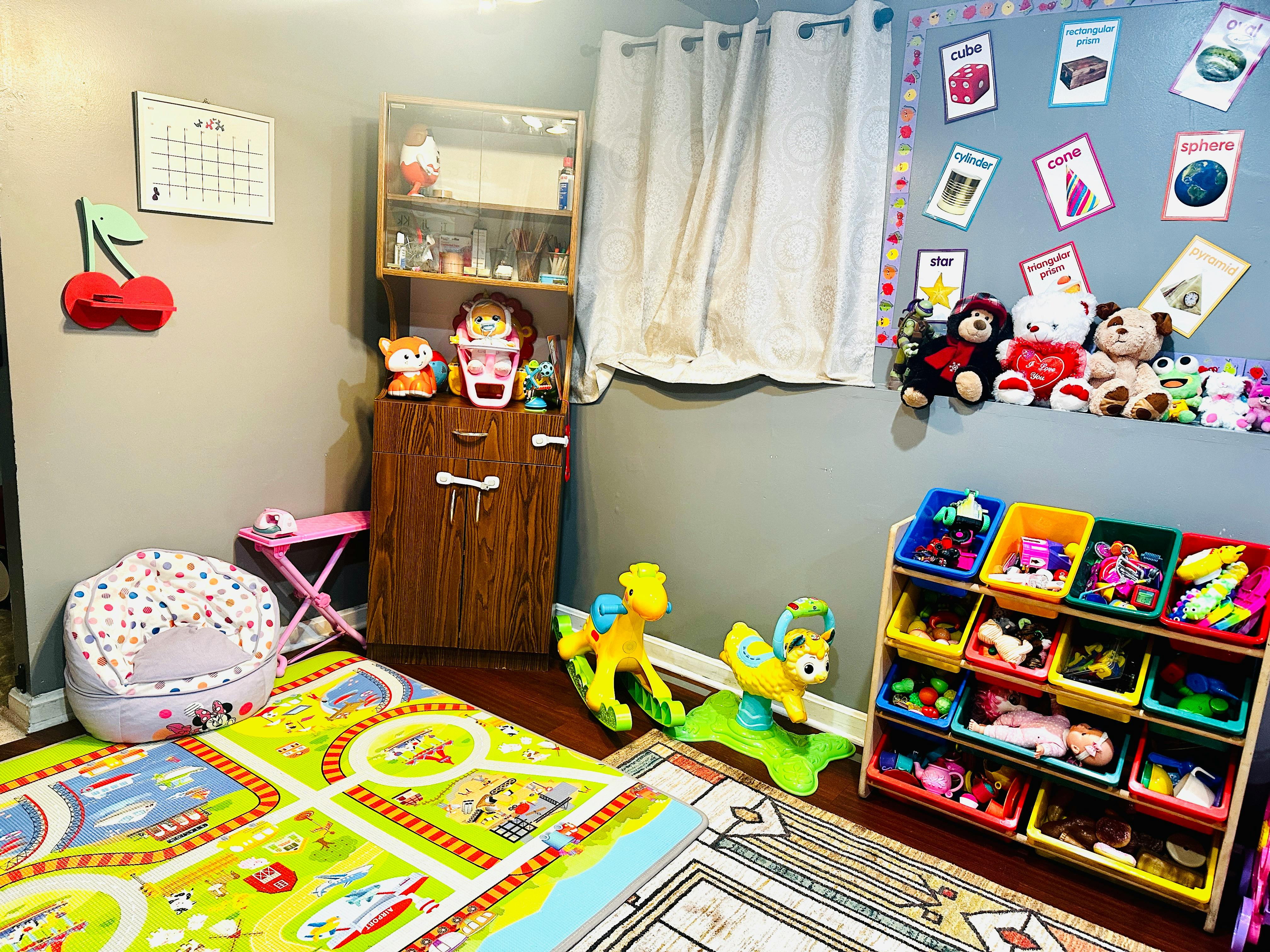 Playroom with a colorful rug, toy storage, and stuffed animals