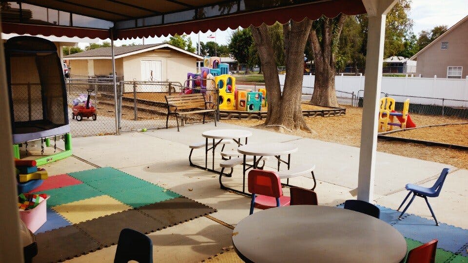 Outdoor patio with tables and chairs next to a playground