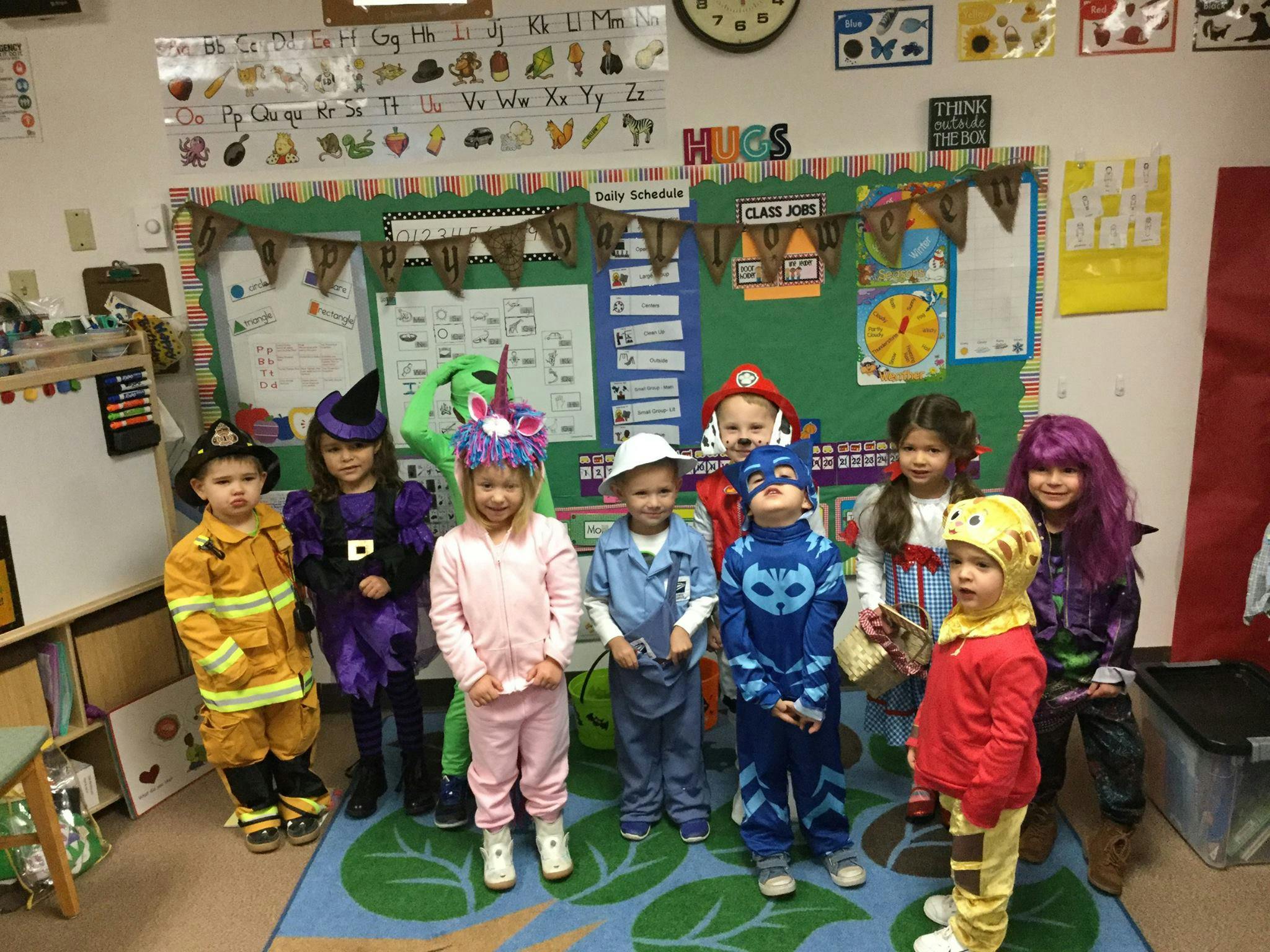 Group of children in costumes standing in a classroom