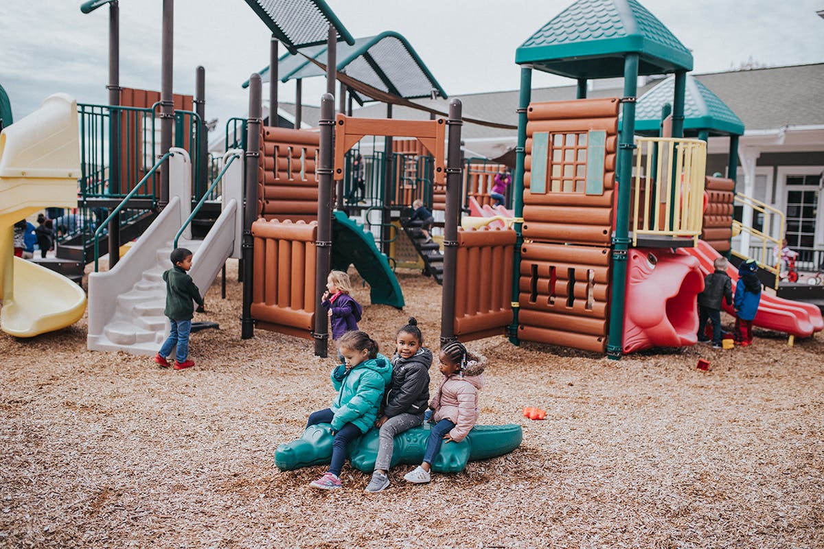 Children playing on a playground with slides and climbing structures
