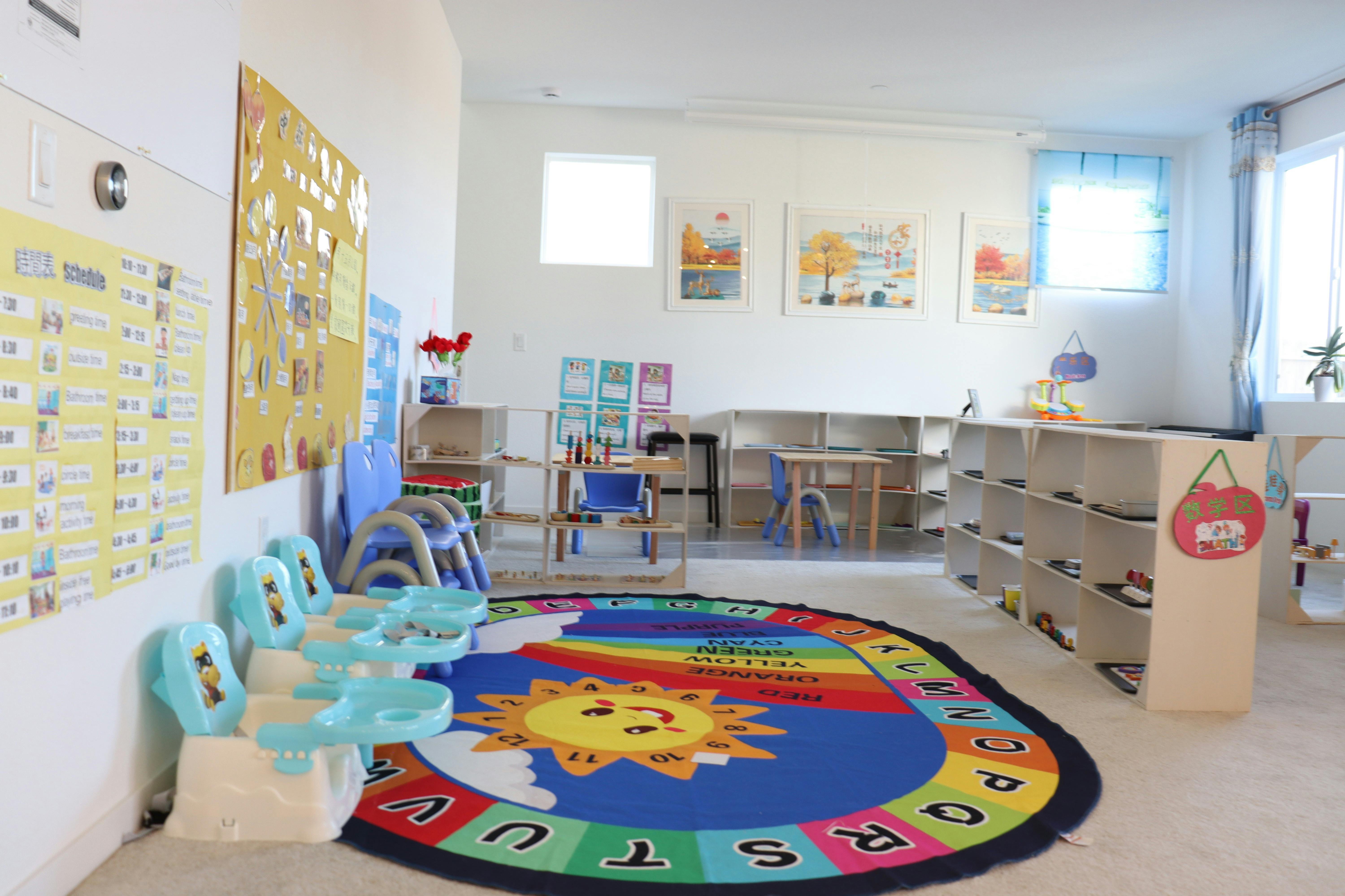 Colorful preschool classroom with small chairs and an alphabet activity rug